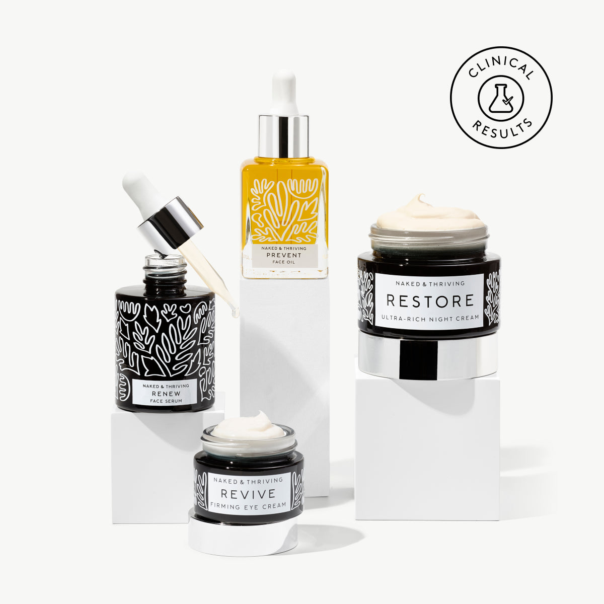 
                
                  Naked & Thriving Anti-Aging Essentials Gift Set of dark, botanical-patterned bottles and jars
                
              