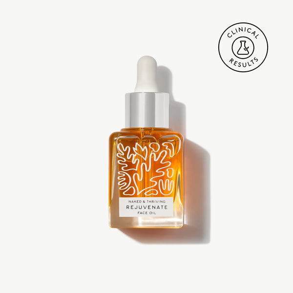 Naked & Thriving Rejuvenate Restorative Face Oil in a clear, botanical-patterned glass dropper bottle