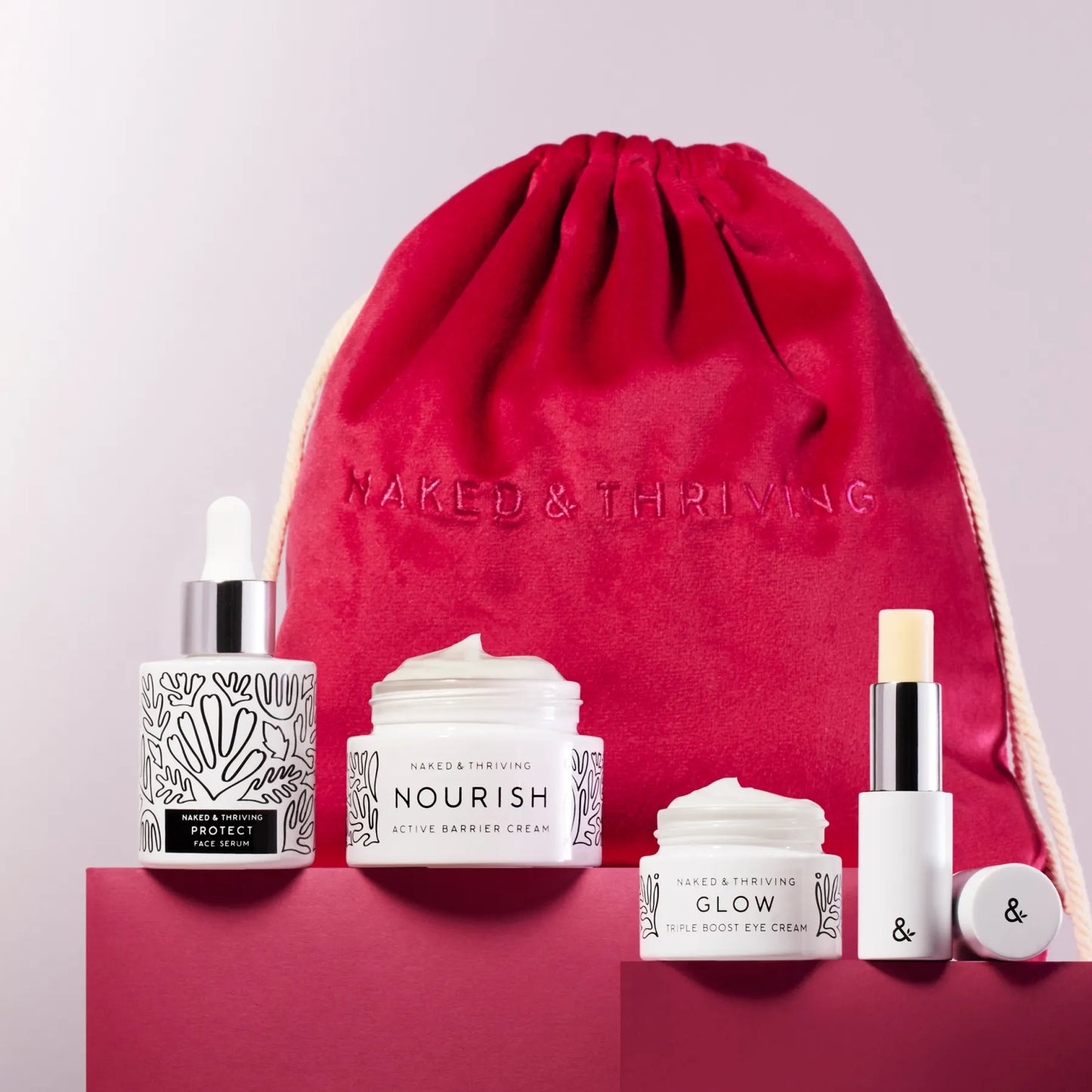 
                
                  Red drawstring gift bag filled with Naked & Thriving skincare products
                
              
